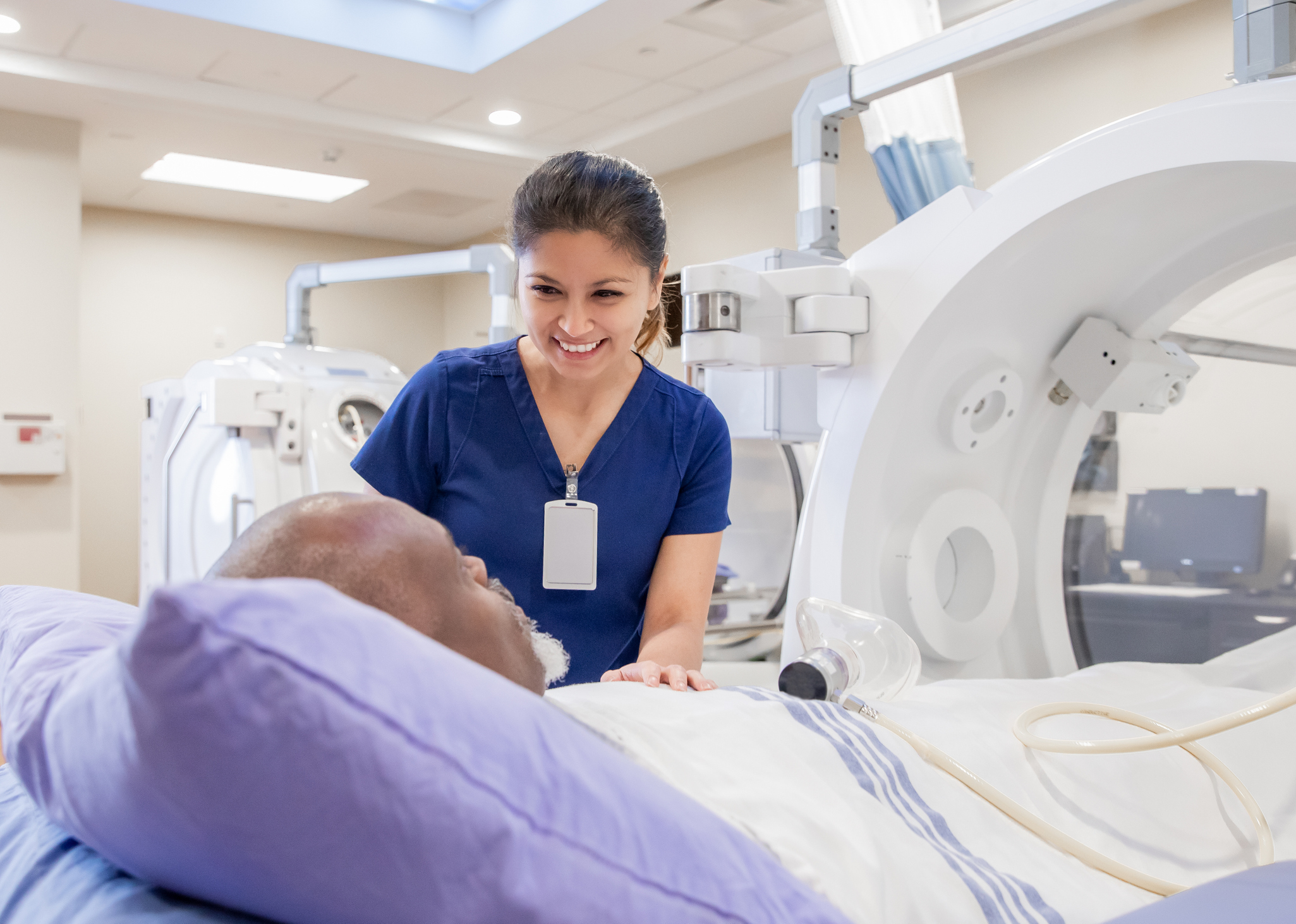 Female nurse prepares senior male for treatment in hyperbaric chamber Female nurse prepares senior male for treatment in hyperbaric chamber